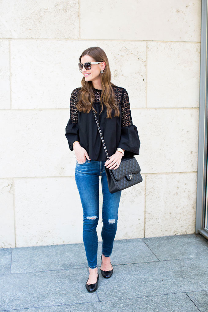 A boho chic black top with lightly distressed jeans, a Chanel double flap bag and black ballet flats