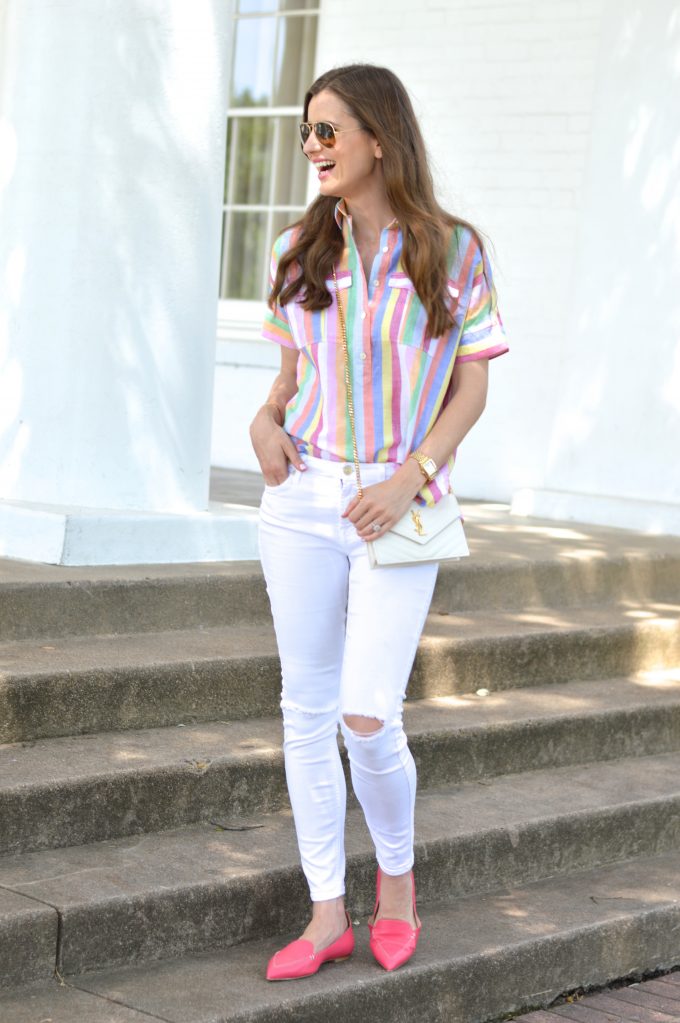 bishop and holland wearing white distressed jeans, a rainbow striped top and a white cross body bag