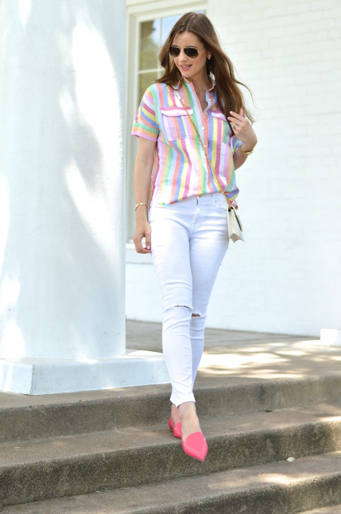 bishop and holland wearing white distressed jeans, a rainbow striped top and a white cross body bag with hot pink loafers