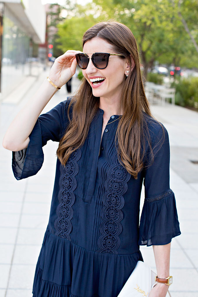 A close up detail of a boho lace dress in navy blue with flutter sleeves.