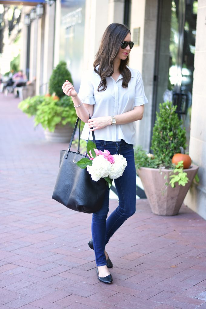 light grey blouse with jeans and black tote bag