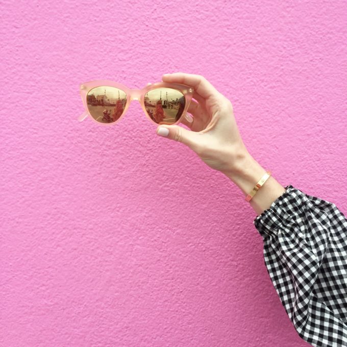 sunglasses against a hot pink wall