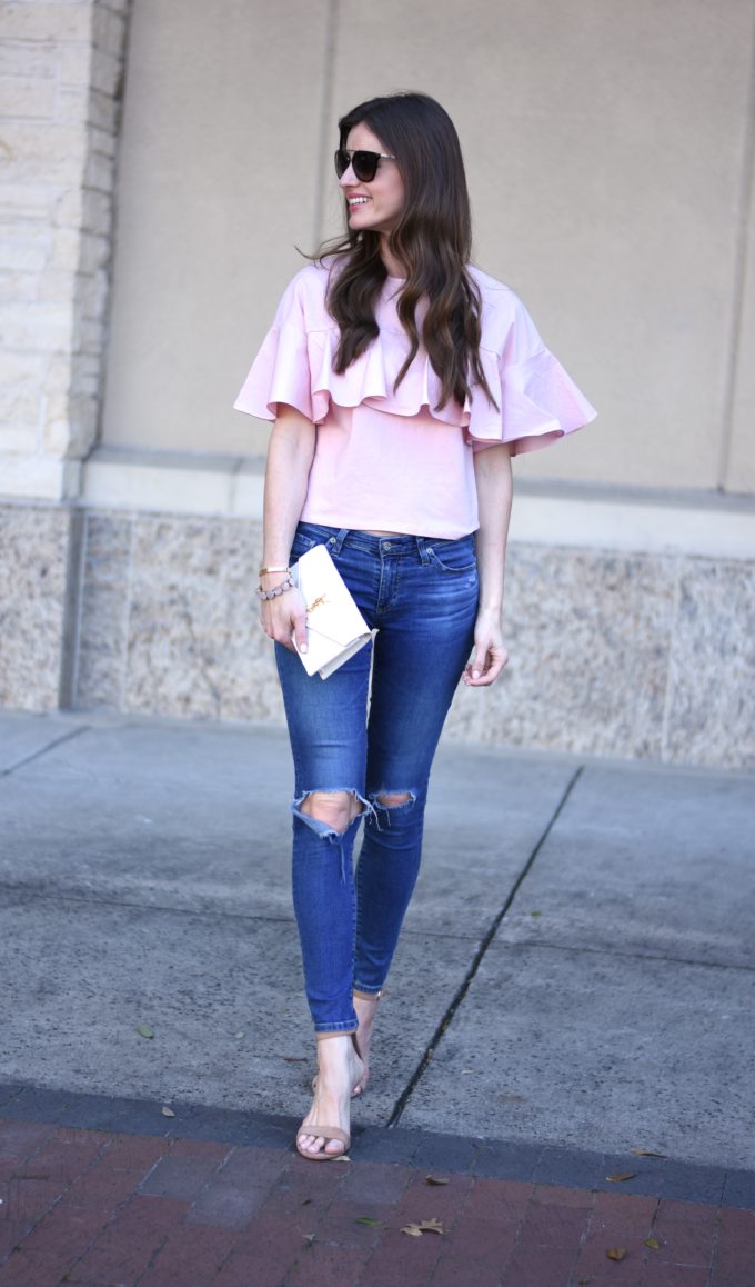 blush pink ruffle top, distressed jeans and white clutch