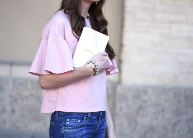 blush pink ruffle top with white clutch