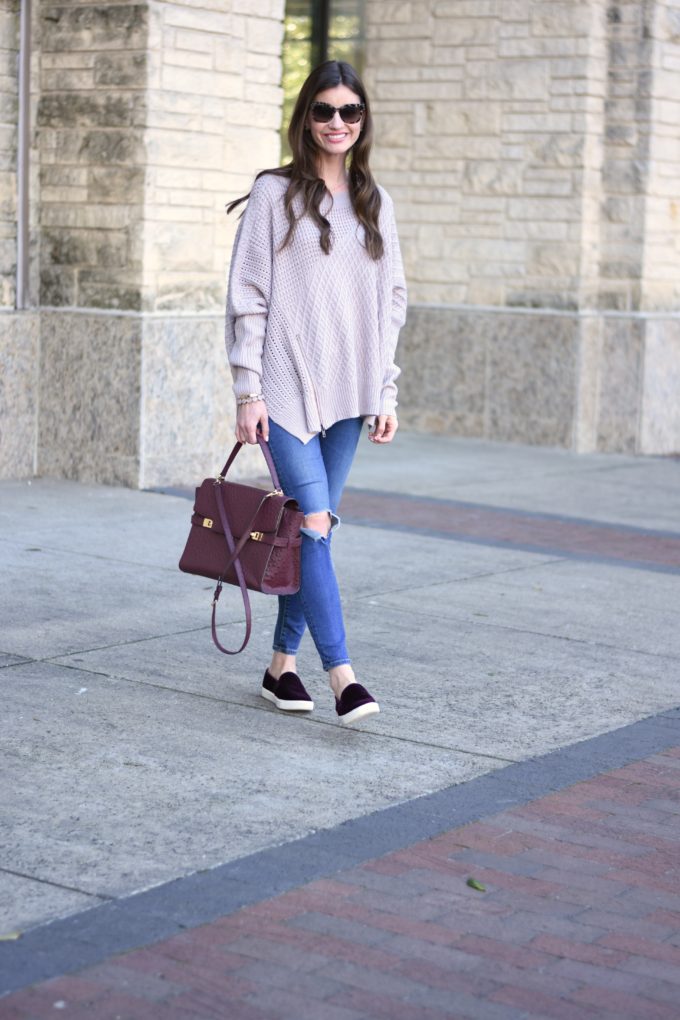 over sized sweater with distressed jeans and burgundy handbag and sneakers