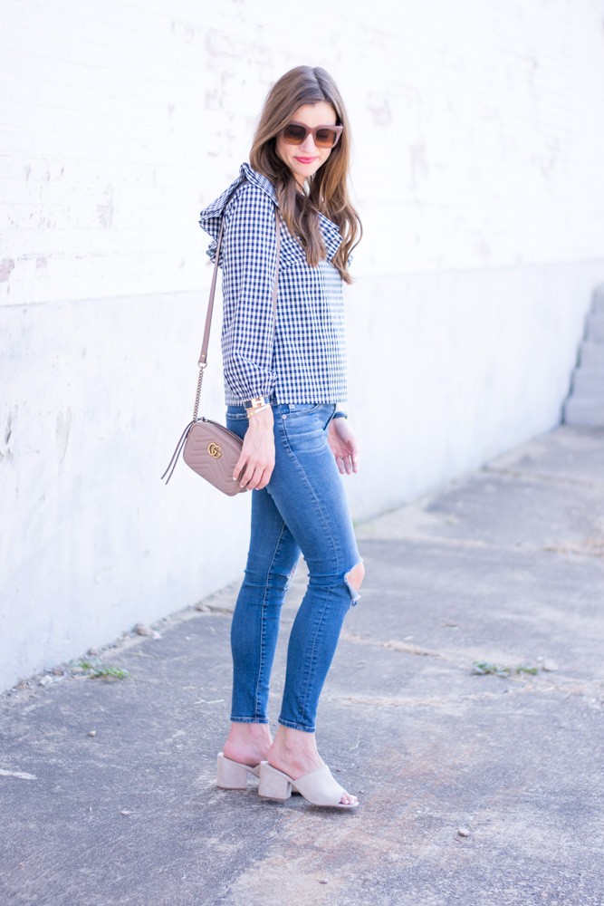 gingham top with distressed jeans nude handbag and mules