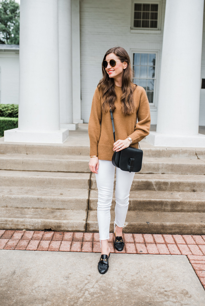 camel sweater white jeans black bag