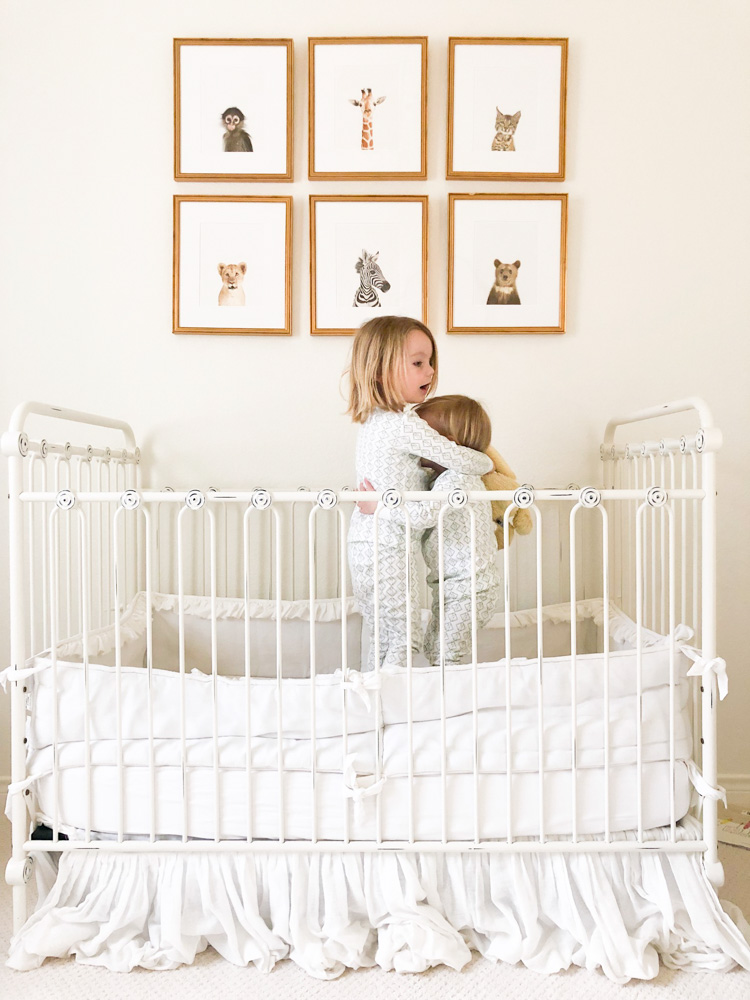 toddler brothers hugging in crib neutral nursery