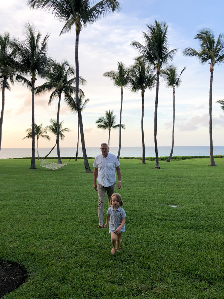 grandfather chasing toddler on lawn