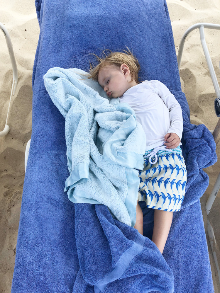 baby boy asleep at the beach