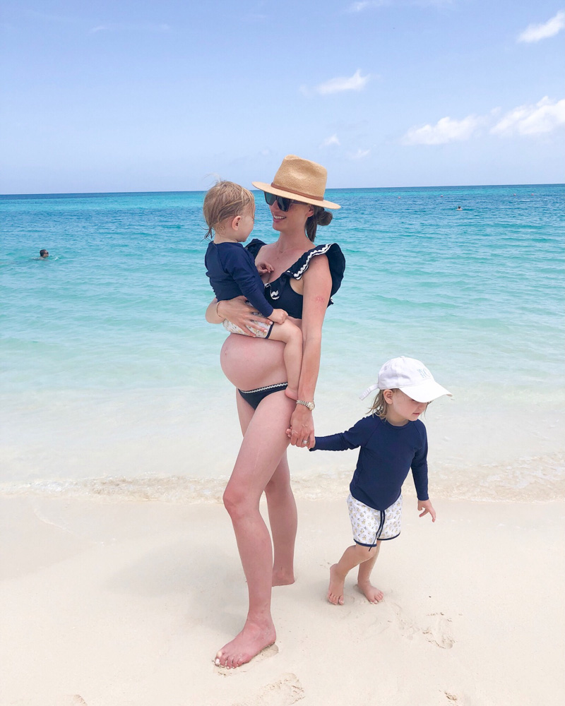 pregnant woman holding toddler with toddler on the beach