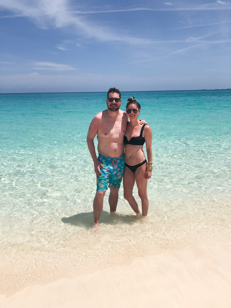 couple standing in ocean on beach