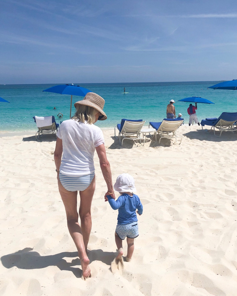 woman and toddler walking on beach