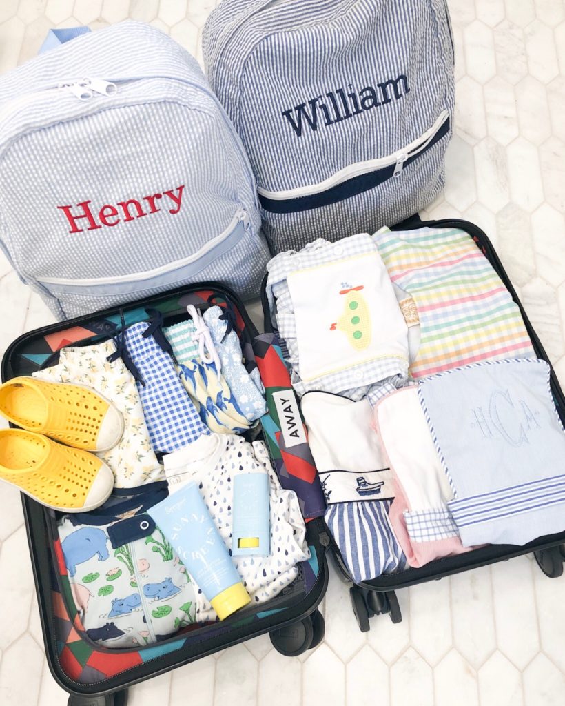 packed suitcase two blu and white striped personalized backpacks