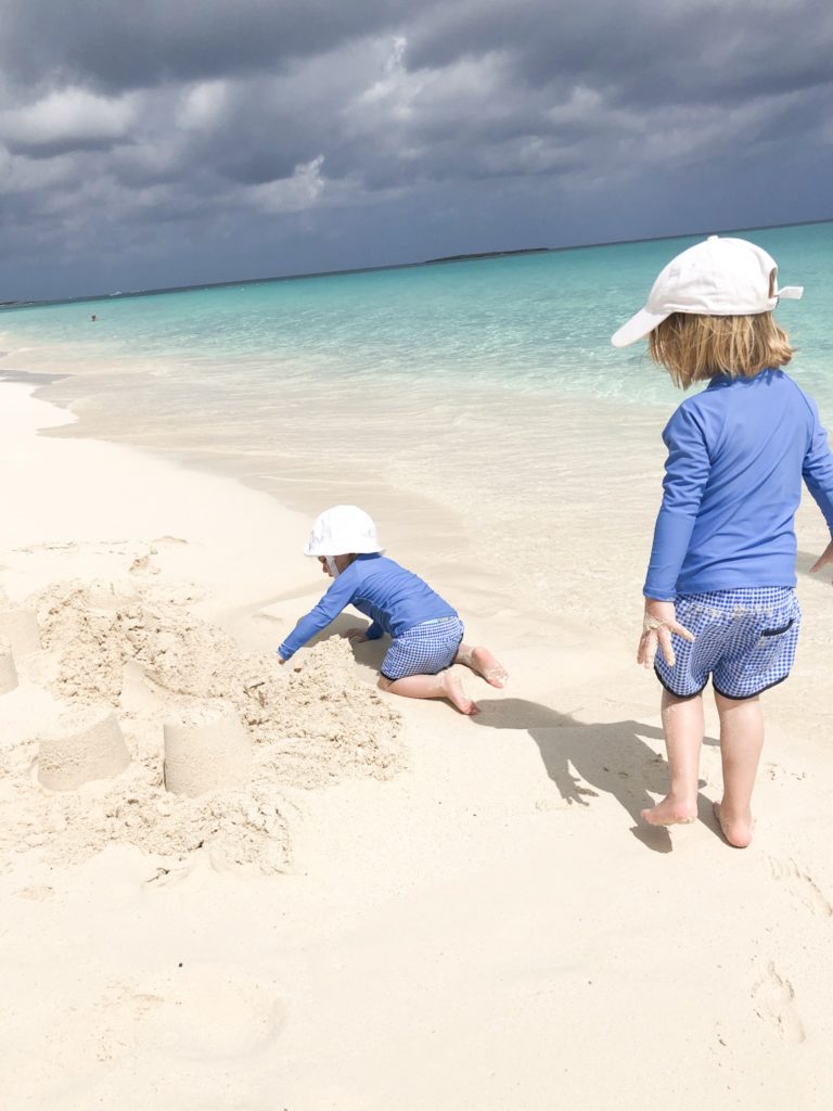 two toddler boys playing on the beach