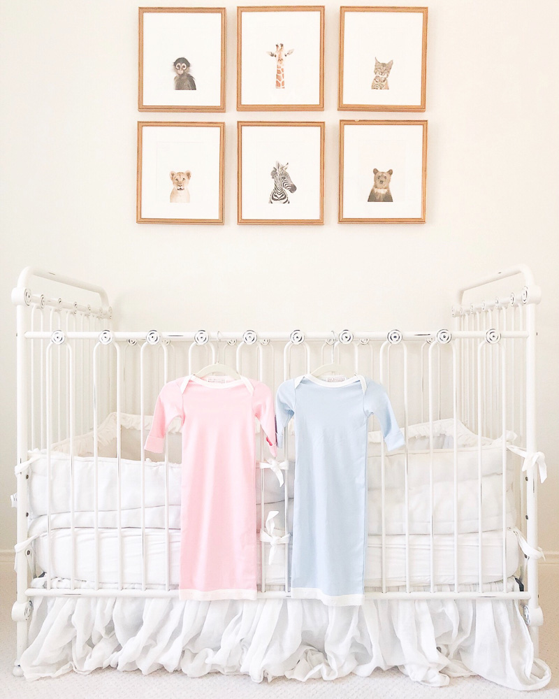 pink and blue newborn nightgowns hanging on crib