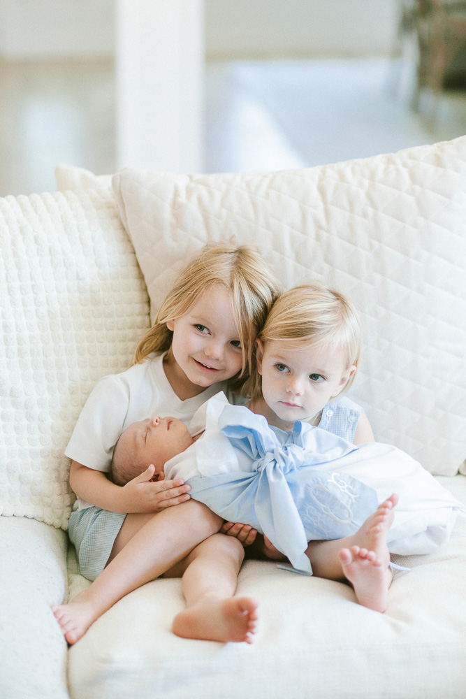 two brothers holding new baby