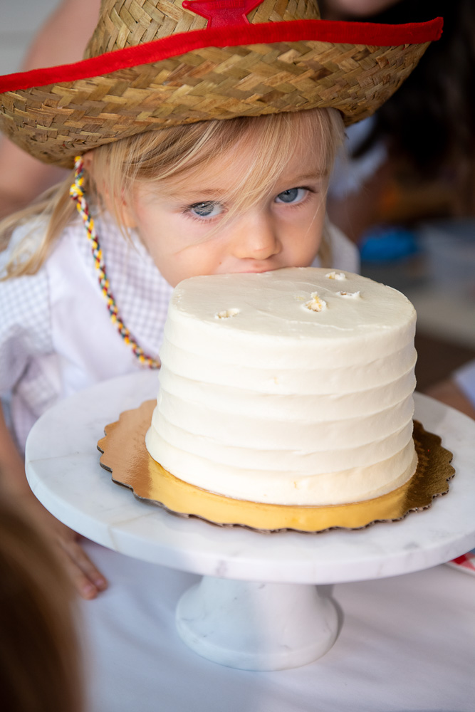 toddler boy taking bite out of birthday cake