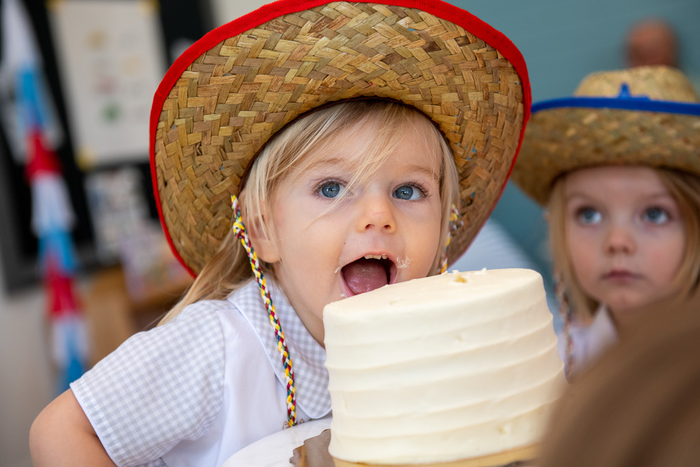 toddler boy taking bite out of birthday cake