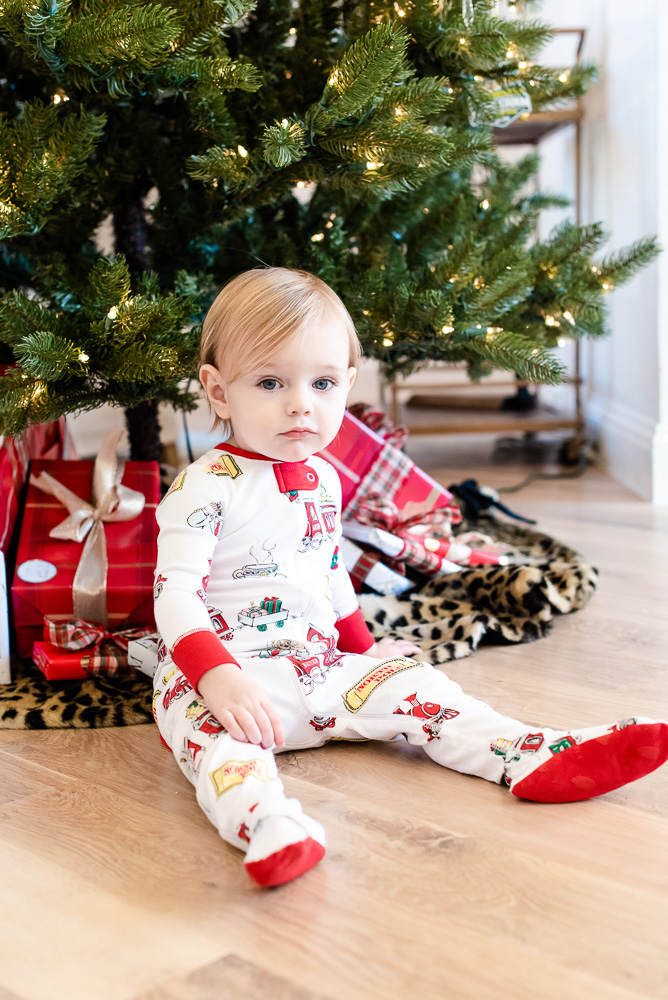 baby boy sitting in front of Christmas tree