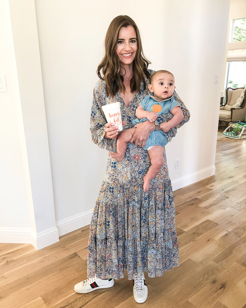 mom in maxi dress holding baby boy in pumpkin outfit