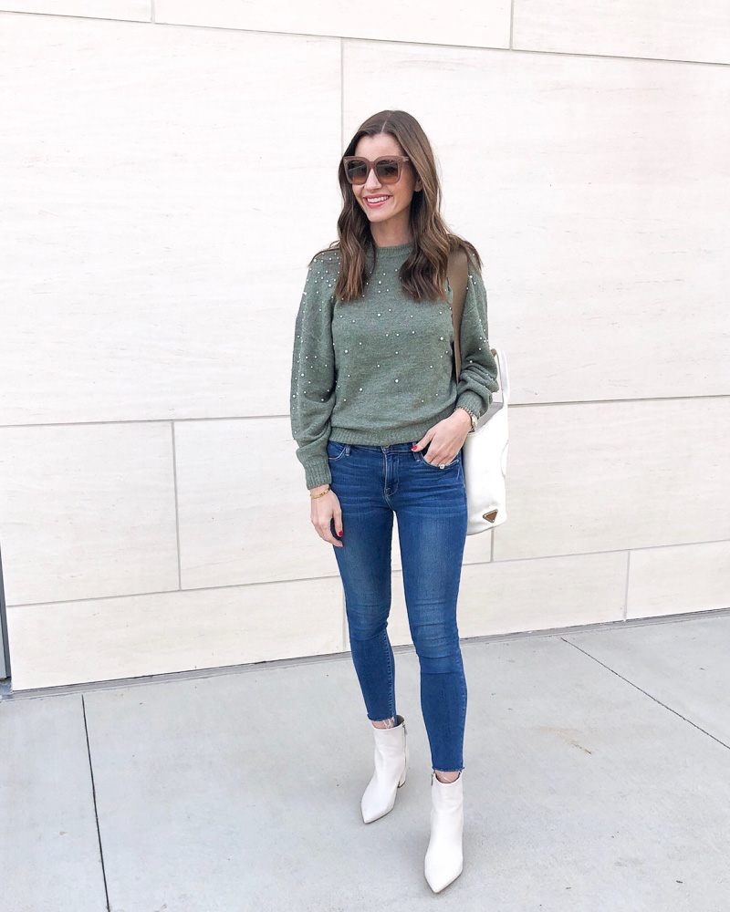 woman in green sweater jeans white booties