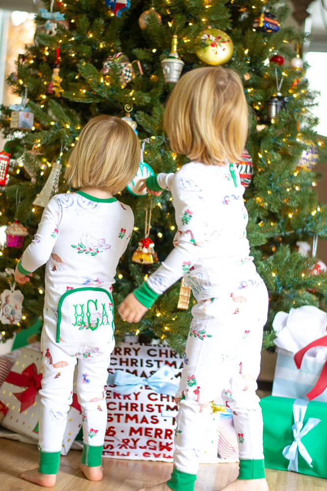 toddler boys by christmas tree in matching pajamas