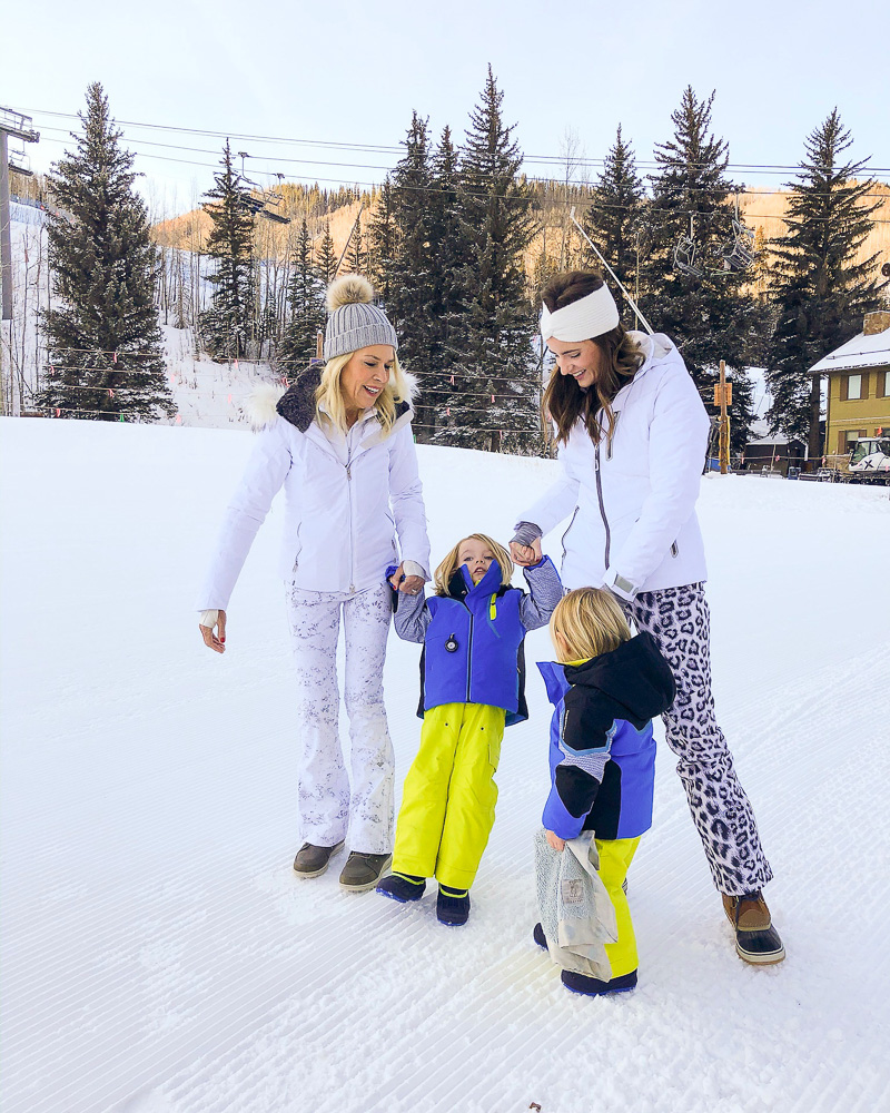 mom and grandmother with toddler boys in the snow