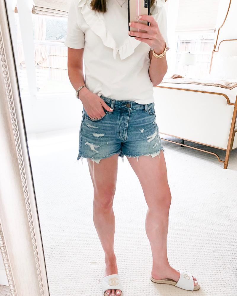 woman wearing white ruffle tee and cutoff shorts