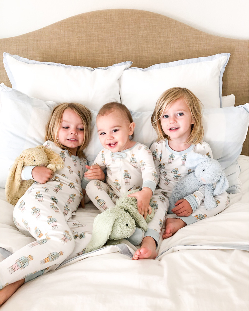 three little boys cuddling in bed in pajamas