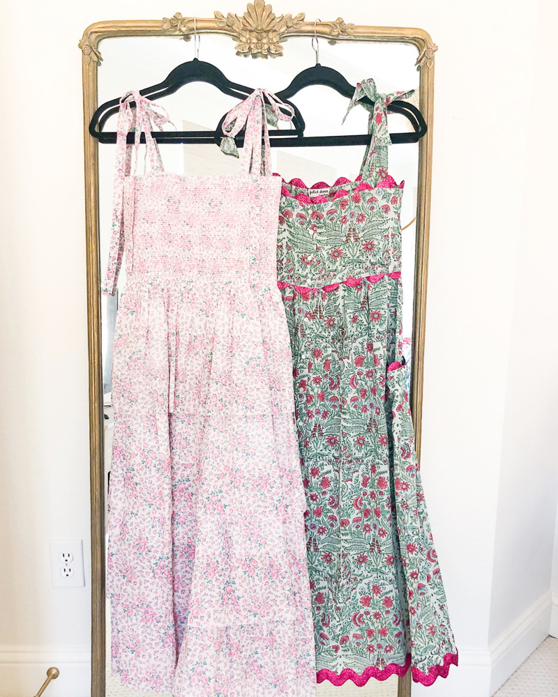 two floral maxi dresses hanging on mirror