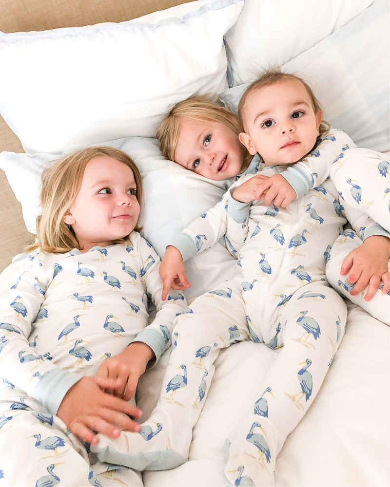 three toddler brothers in pajamas in bed
