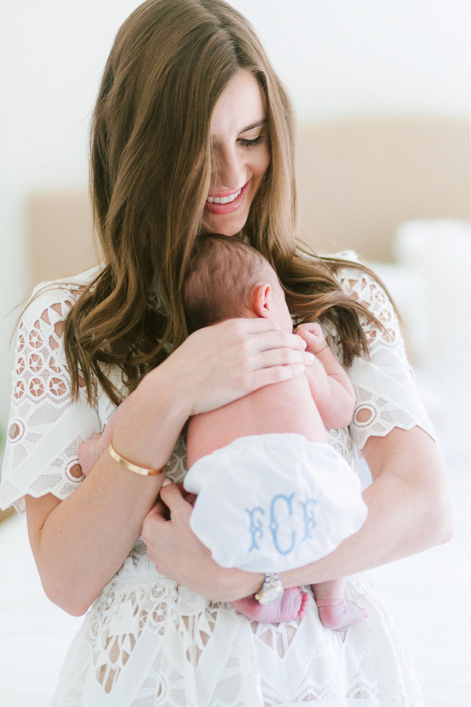 mom holding newborn baby with monogram diaper cover