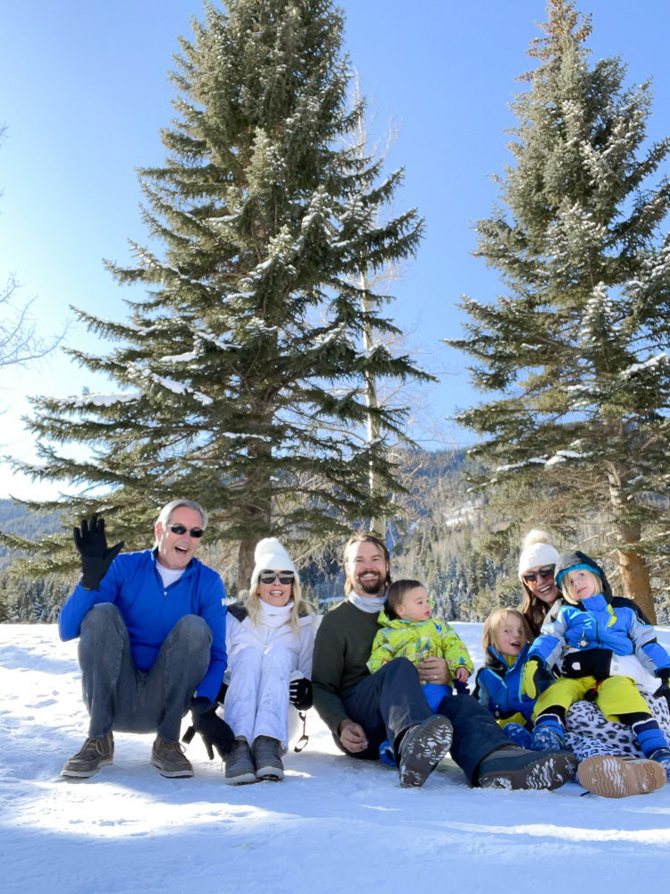 family sitting on a snowy hillside