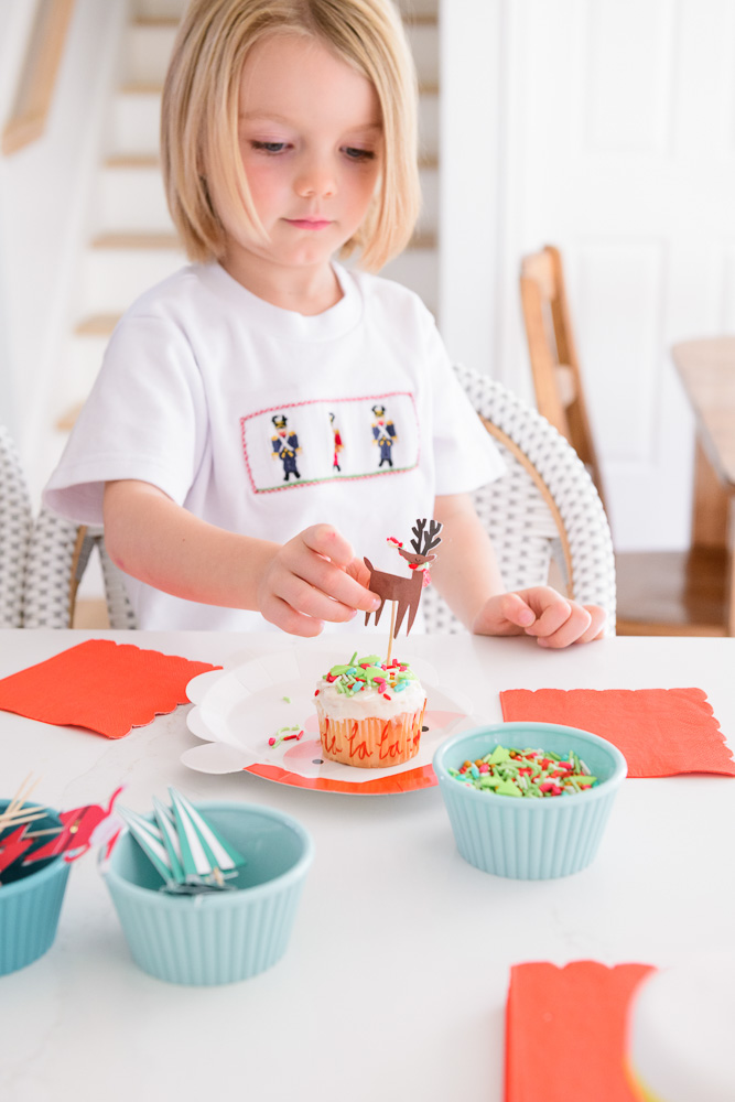 toddler boy decorating cupcake