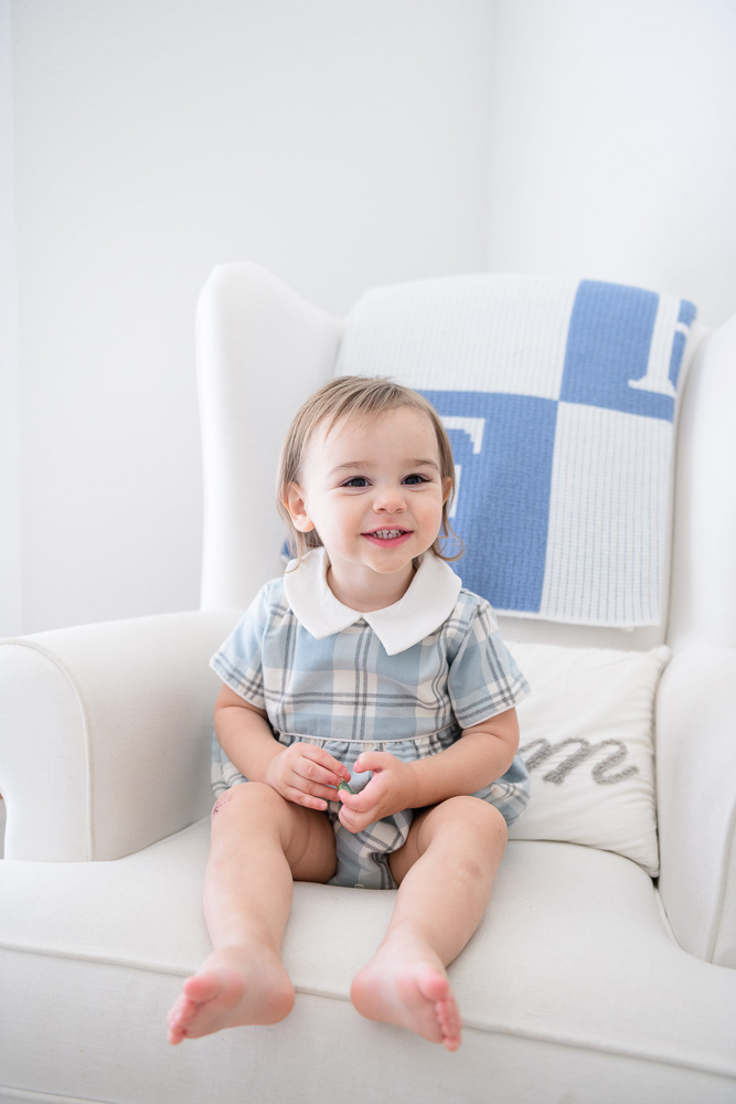 baby boy sitting in rocking chair smiling