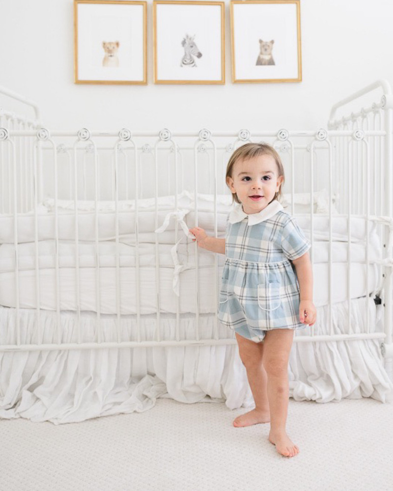 toddler boy standing by crib