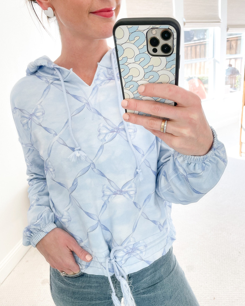 woman in mirror in blue bow sweatshirt