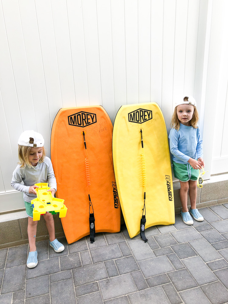 two toddler boys with boogie boards