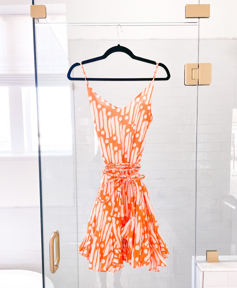 orange and white mini dress hanging on shower door