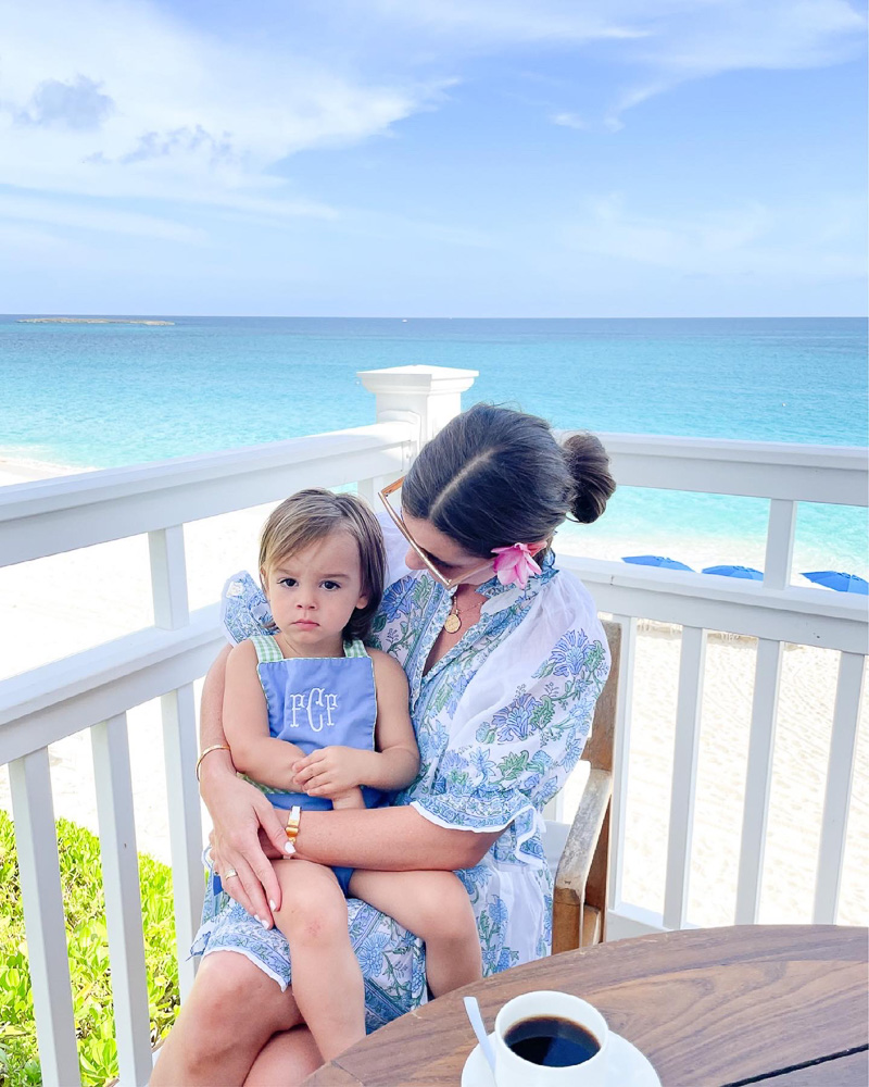 mom holding toddler with view of ocean