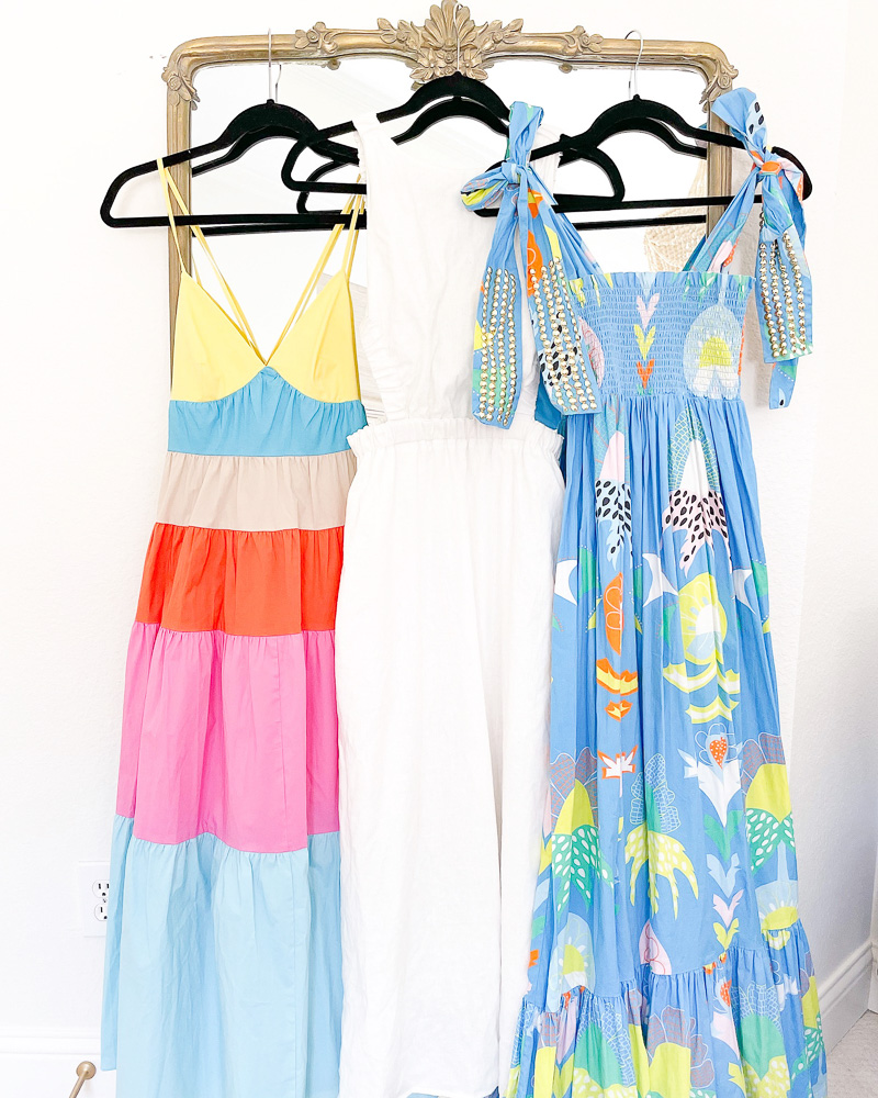 three summer maxi dresses hanging on mirror