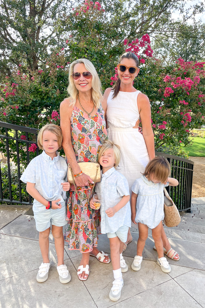 two women in summer dresses with three little boys in matching short sets