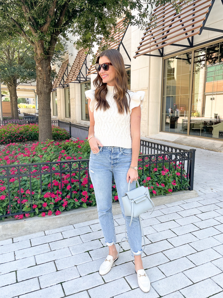 woman wearing short sleeve ruffle sweater with jeans and white mules