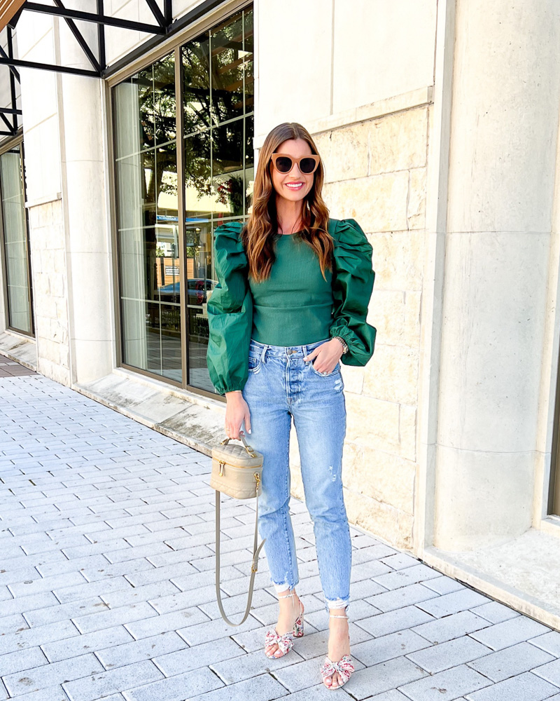 woman wearing green puff sleeve top jeans and bow sandals