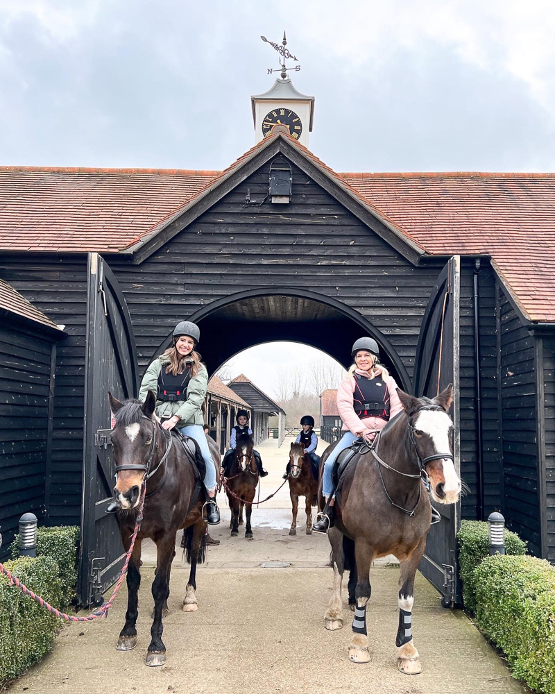 two women riding horses english countryside