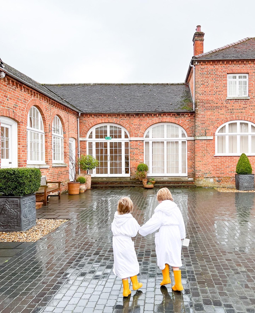 two little boys running across brick courtyard english countryside