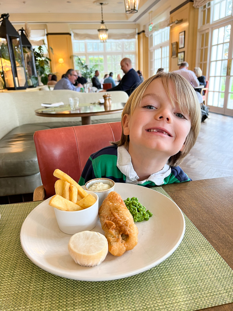 little boy eating fish and chips
