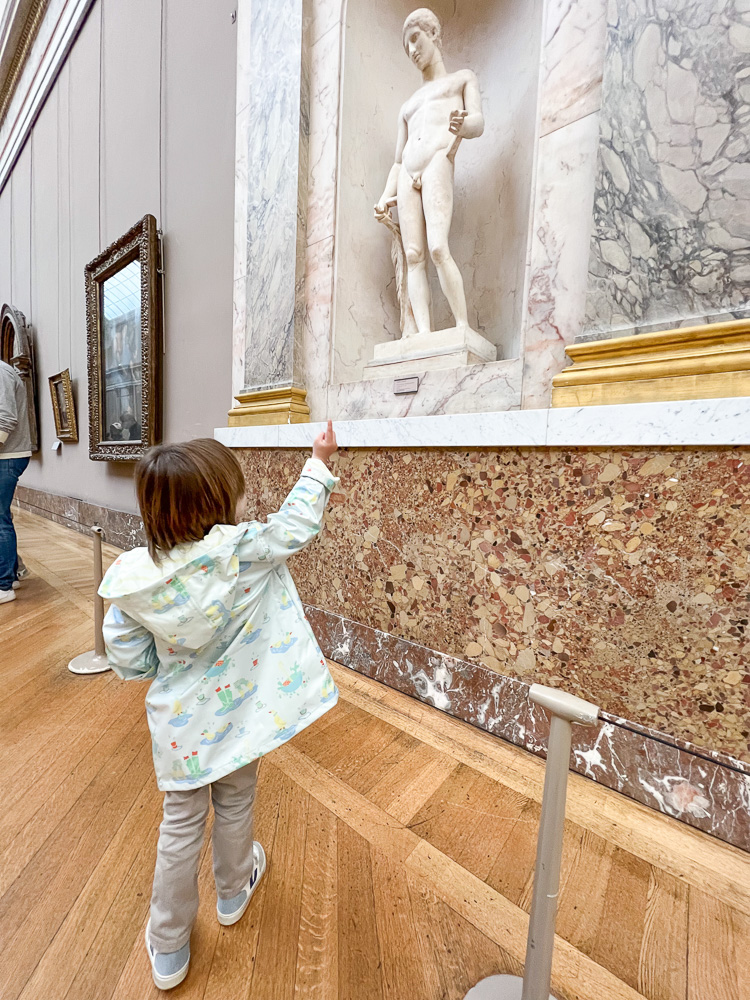 toddler boy looking at sculpture in the ;ouvre