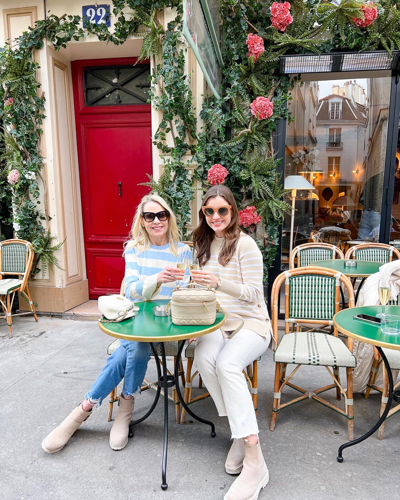 two women having champagne outside a cafe in paris